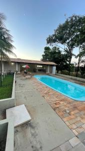a swimming pool in front of a house at Chacara dos Sonhos Votuporanga in Votuporanga