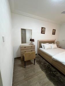 a bedroom with a bed and a dresser and a mirror at Masare home in New Weija