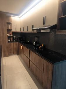 a kitchen with wooden cabinets and black counter tops at Alojamiento Acogedor de la mejor zona de Loja in El Recreo