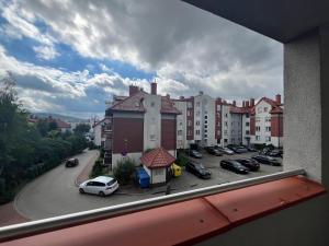a view from a window of a parking lot with cars at Apartament NA WRZOSACH in Kielce