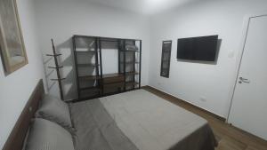 a living room with a couch and a tv at Casa no Centro de São Roque - SP in São Roque