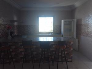 a kitchen with bar stools and a counter with a window at Christiana 7 Midoun in Midoun