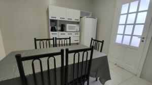 a kitchen with a table and chairs and a refrigerator at Casa no Centro de São Roque - SP in São Roque +15 photos