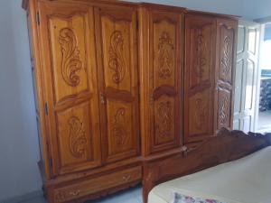 a wooden cabinet is sitting next to a bed at Christiana 7 in Midoun