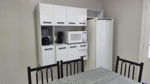 a kitchen with a white refrigerator and a microwave at Casa no Centro de São Roque - SP in São Roque