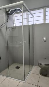 a glass shower in a bathroom with a toilet at Casa no Centro de São Roque - SP in São Roque