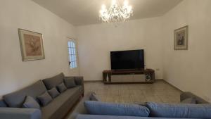 a living room with a couch and a television at Casa no Centro de São Roque - SP in São Roque