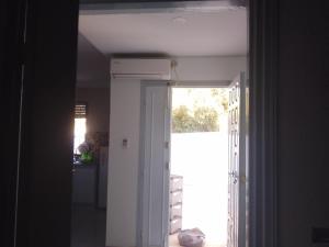 a hallway with a door open to a kitchen with a window at Christiana 7 in Midoun