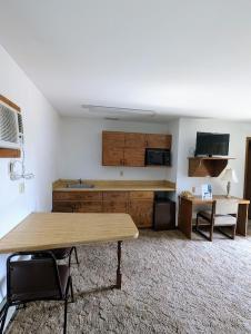 a living room with a table and a kitchen at Cool City Motel in Two Rivers