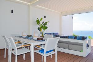 a dining room with a table and chairs and a couch at New Condo Eternal Sea - 3 Bedrooms in Koolbaai