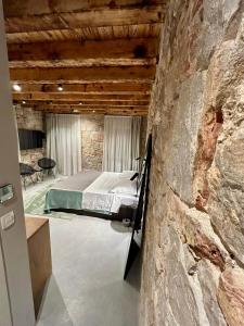 a bedroom with a bed in a stone wall at Piazza room in Split