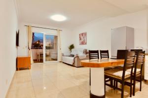 Una sala de estar con una mesa y sillas y un sofá. en central in Los Cristianos Balcony and beach on foot, en Los Cristianos 21 fotos más