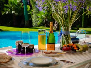 a table with a bottle of champagne and a plate of food at L'Introvabile Luxury Suite Cesena in Cesena
