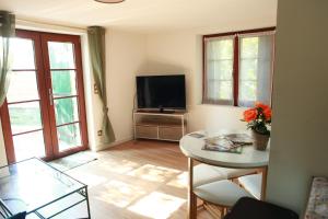un soggiorno con tavolo e TV a schermo piatto di Appartement romantique à 5mn de la cathédrale d'Albi ad Albi