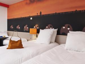 a hotel room with two beds with white pillows at ibis Styles Paris Tolbiac Bibliotheque in Paris
