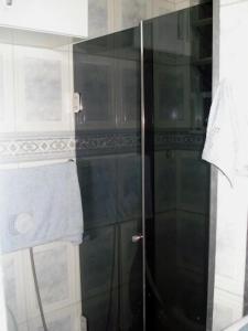 een douche met een glazen deur in een badkamer bij Studio em Copacabana in Rio de Janeiro