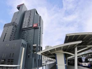 a tall building with a red sign on it at Mercure Bangkok Siam in Bangkok