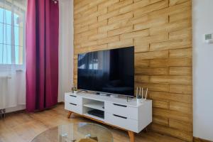 a living room with a television on a wooden wall at Relax & Luxury apartment in Veľká Lomnica