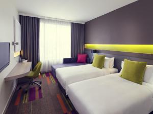 a hotel room with two beds and a tv at Mercure Bangkok Siam in Bangkok