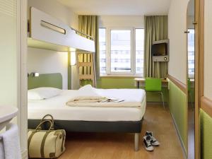 una camera d'albergo con un letto e una scrivania di ibis budget Aachen City ad Aquisgrana Altre 34 foto