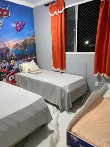 Dos camas en una habitación con un mural en la pared. en Apt Santa Cruz, en Santa Cruz