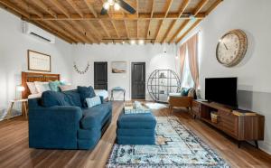 a living room with a blue couch and a tv at Charming & Spacious Hideaway by Downtown Bryan in Bryan