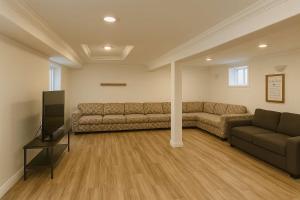 un salon avec deux canapés et une télévision à écran plat dans l'établissement Melrose Place Poolside Hideaway Basement Suite Sleeps 6 plus, à Victoria