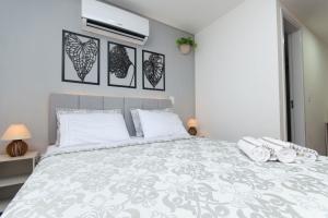 a bedroom with a large white bed with white pillows at Estúdio aconchegante no centro de Poços de Caldas in Poços de Caldas +25 photos