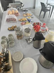a table with food and plates on top of it at Pousada Canta Galo in Goiás