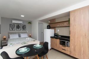 a bedroom with a bed and a table and chairs at Estúdio aconchegante no centro de Poços de Caldas in Poços de Caldas