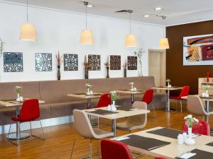 a restaurant with tables and chairs and paintings on the wall at ibis Adana in Adana