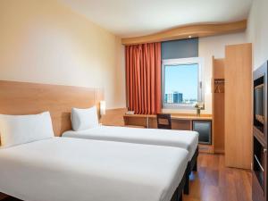 a hotel room with two beds and a window at ibis Adana in Adana