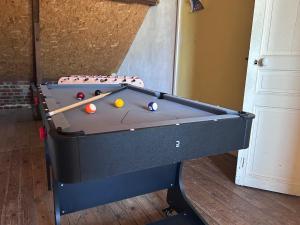 a pool table with two balls and two cues at Maison chic et cosy in Roye