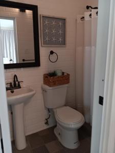 a bathroom with a toilet and a sink and a mirror at V7 Pr Rental Cozy Room & Great Location in San Juan
