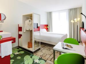 a hotel room with a bed and a mirror at ibis Styles Karlsruhe Ettlingen in Ettlingen