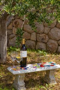 eine Flasche Wein und zwei Gläser auf einer Bank in der Unterkunft Urlaubsdomizil in Kroatien - willkommen in Bribir