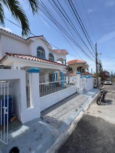 a white house with a fence in front of it at villa costeña piscina privada in San Felipe de Puerto Plata