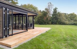 a house with a wooden deck in a field at 3 Bedroom Stunning Home In Grenaa in Grenå +7 photos