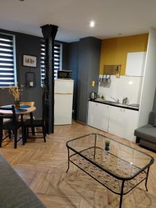 Una sala de estar con una mesa y una cocina. en SPIN City by Katowice # One & Z E R O, en Katowice