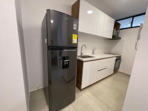 a stainless steel refrigerator in a small kitchen at Amara 304- Amplio y comodo Apartamento en Laureles in Estación El Salto