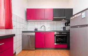 a kitchen with pink cabinets and a sink at Lovely Apartment In Maslenica With House Sea View in Šarić