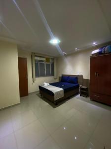 a bedroom with a blue bed and a cabinet at Apartamento inteiro in Itaperuna