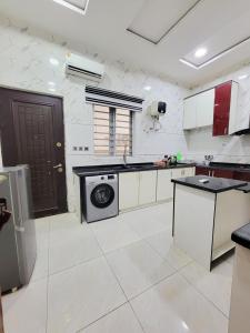 une grande cuisine avec un lave-linge et un sèche-linge. dans l'établissement Lunar, à Mama