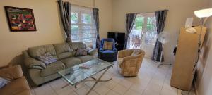 a living room with a couch and a glass table at Homey Haven in Willemstad