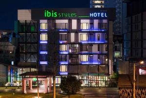 Un edificio de hotel con luces azules por la noche. en ibis Styles Chiang Mai, en Chiang Mai