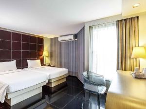 una habitación de hotel con una cama y una silla en ibis Styles Chiang Mai, en Chiang Mai