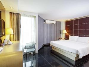 una habitación de hotel con una cama y un escritorio en ibis Styles Chiang Mai, en Chiang Mai