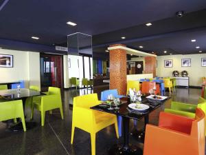 a dining room with tables and colorful chairs at ibis Styles Chiang Mai in Chiang Mai