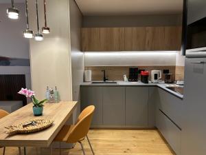 eine kleine Küche mit einem Holztisch sowie einem Tisch und Stühlen in der Unterkunft Exclusive flat on Lake Como with panoramic views in Como + 22 Fotos