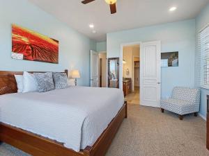 Un dormitorio con una cama grande y una silla. en Ocean View Villa Sunset Pool King's Luxury experience, en Kailua-Kona